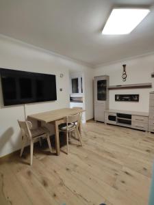 a living room with a table and chairs and a television at Apartament " Uznam" w centrum Świnoujścia in Świnoujście