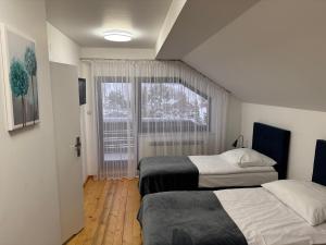 Dos camas en una habitación pequeña con ventana. en Salmopolskie Zacisze, en Szczyrk 70 fotos más