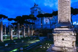 een gebouw met een zuil op een kerkhof 's nachts bij Hotel Leone in Rome