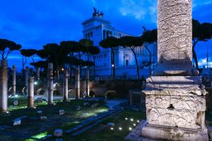 a building with a column in a cemetery at night at Hotel Leone in Rome