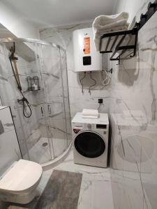 a white bathroom with a toilet and a shower at Apartament " Uznam" w centrum Świnoujścia in Świnoujście