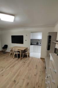 a living room with a table and a kitchen at Apartament " Uznam" w centrum Świnoujścia in Świnoujście +4 photos