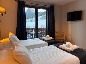 two beds in a room with a large window at Résidence Frond'Neige in Morzine +36 photos