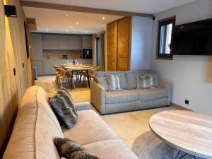 a living room with a couch and a table at Résidence Frond'Neige in Morzine