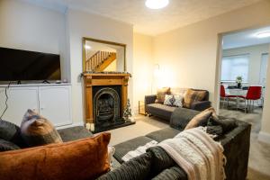 a living room with a couch and a fireplace at Edwards House, Sleeps 5 in 3 bedrooms, Bath Road, Cheltenham in Cheltenham