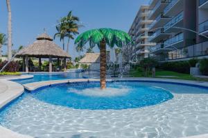 a palm tree in the middle of a pool with a fountain at Apartment with pool 3 beds in Acapulco in Acapulco
