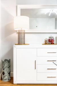 een witte kast met een lamp erop bij Comfortable house in Fuengirola with terrace in Fuengirola