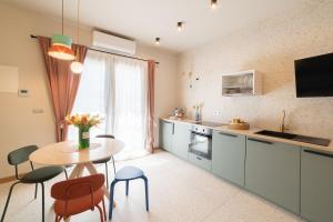 una cucina con tavolo, sedie e finestra di Leopardi Design with 2 bathrooms ad Alba Adriatica