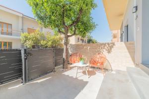 due sedie e un tavolo di fronte a una recinzione di Leopardi Design with 2 bathrooms ad Alba Adriatica