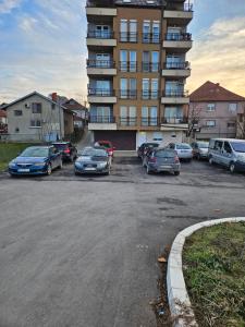 a parking lot with cars parked in front of a building at Apartman Helena 2 in Lazarevac