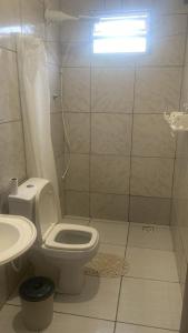 ein Badezimmer mit Toilette, Dusche und Waschbecken in der Unterkunft Casa de férias em Gravatá, Navegantes perto da praia in Navegantes