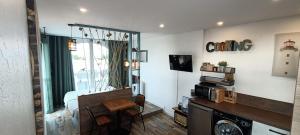 a living room with a bed and a room with a window at Le Sémaphore - studio climatisé, grande terrasse vue mer - parking, wifi in La Grande Motte