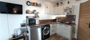 a kitchen with a washing machine and a microwave at Le Sémaphore - studio climatisé, grande terrasse vue mer - parking, wifi in La Grande Motte