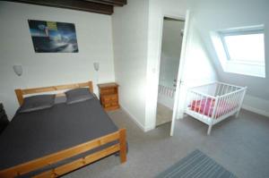 a bedroom with a bed and a crib in it at La Grange du Devezou in Saint-Jacques-des-Blats +40 photos