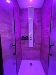 a bathroom with a shower with purple lighting at Appartement LOVE ROOM LUXE in Bavay