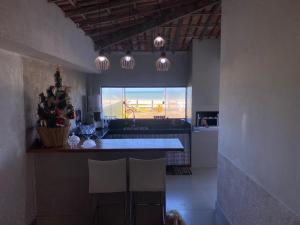 a kitchen with a sink and a counter with a window at Suites Frente ao Mar in Prado