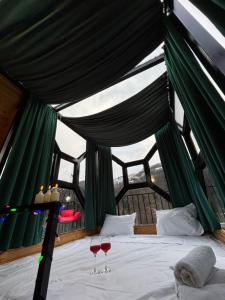 a bedroom with a bed with two glasses of wine at Turo House Meris in Inasharidzeebi