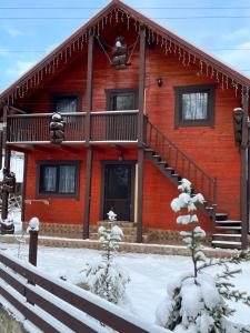 a log cabin with a staircase in the snow at Незабутні Карпати in Vorokhta