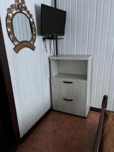 a television and a cabinet with a mirror in a room at Незабутні Карпати in Vorokhta