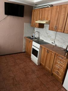 a kitchen with wooden cabinets and a white stove top oven at Незабутні Карпати in Vorokhta