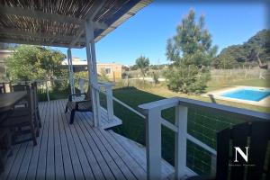 a deck with a table and chairs and a pool at Hermosa casa en Costa Esmeralda in Costa Esmeralda +10 photos