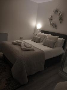 a bedroom with a large bed with two towels on it at Mudeford Gem Accommdation in Christchurch