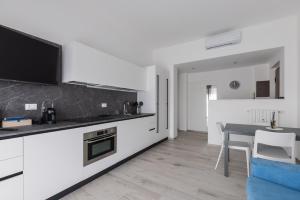 a kitchen with white cabinets and a table with a counter top at Casa Teresa - Luminosa eleganza in Asti +10 photos