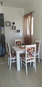 a white dining room table with two chairs and a table at Jelena in Igalo +5 photos