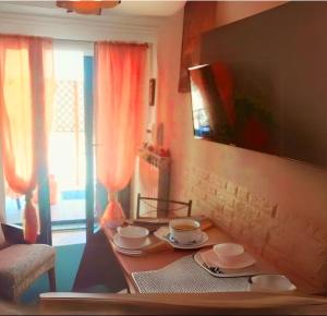 un tavolo con tazze e piattini sopra di esso in una stanza di Alba Sweet ad Alba Adriatica