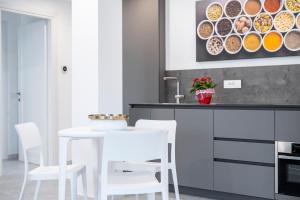 een keuken met een witte tafel en witte stoelen bij Appartamento Guglielmo in Oristano