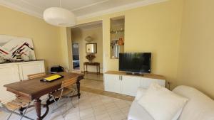 Una sala de estar con un sofá y una mesa con televisión. en Appartamento Stella Marina a due passi dal mare e dal centro, en Marina di Carrara
