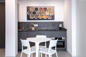 een eetkamer met een witte tafel en witte stoelen bij Appartamento Guglielmo in Oristano