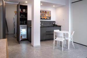 een keuken met een witte tafel en witte stoelen bij Appartamento Guglielmo in Oristano +33 foto's