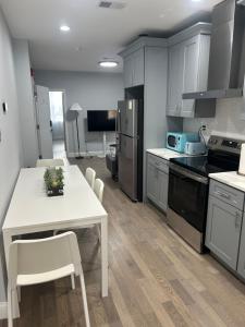 una cucina con tavolo e tavolo e sedie bianchi di Cozy 2-3 Bedroom Apartment in Center City! a Philadelphia