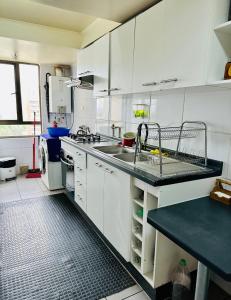 a kitchen with white cabinets and a sink at Departamento en Santiago cercano a aeropuerto y metro in Santiago