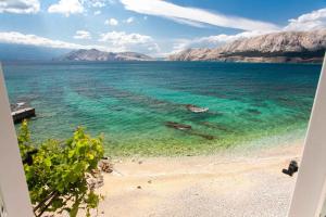 a beach with clear water and mountains in the background at Apartments in Baska - Insel Krk 41026 in Baška
