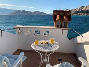 a table on the balcony of a boat at Apartments in Baska - Insel Krk 41026 in Baška