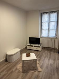a living room with a coffee table and a tv at Appartement plein centre in Aubusson