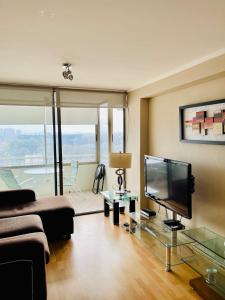 a living room with a flat screen tv and a couch at Departamento en Santiago cercano a aeropuerto y metro in Santiago