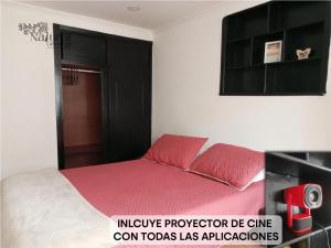 a bedroom with a bed with red pillows at Azrael NATURAL GETAWAY MOVISTAR ARENA in Bogotá