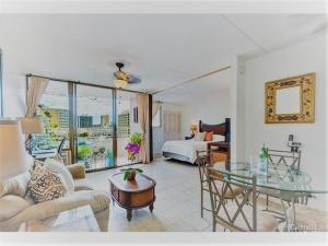 un salon avec un lit et une table en verre dans l'établissement Island Vacations, à Honolulu