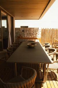 ein Tisch mit Stühlen und einer Schüssel darauf in der Unterkunft Casa Believe Milagres in Passo de Camarajibe