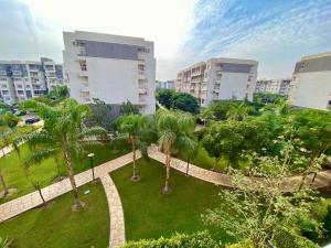 un parque con palmeras y edificios en una ciudad en Warm Home for You Free Wifi, en Madinaty
