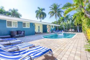 フォート・ローダーデールにあるHeated Saltwater Pool 6min to Beach Tropical Oasisのラウンジチェア付きのスイミングプール、家