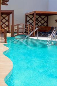 a swimming pool with blue water in a building at Pousada Barra De Maragogi in Maragogi +18 photos
