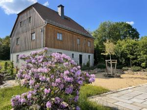 DürrröhrsdorfLandQuartier - La Primera的前面一个种有紫色花的大谷仓