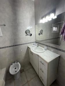 a bathroom with a sink and a toilet and a mirror at Casa Familiar en Miramar in Miramar +8 photos