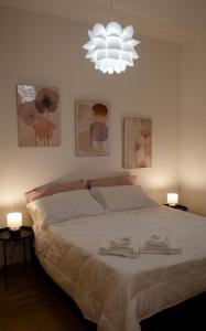 a bedroom with a large white bed with two lamps at Piccola Bologna in Casalecchio di Reno