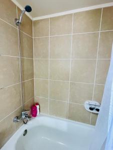 a bathroom with a bath tub with a shower at Departamento en Santiago cercano a aeropuerto y metro in Santiago +39 photos