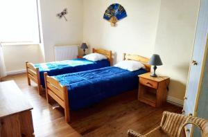 a bedroom with two beds and a table with a lamp at Maison charmante à Mercœur avec jardin et parking in Mercoeur